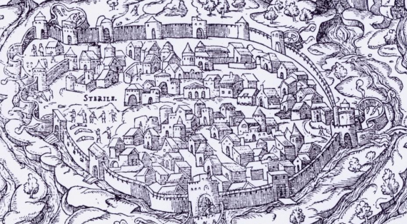  Perpignan vue du Nord avec une enceinte crénelée , le bastion du castillet, la tête en avant et des montagnes en fond