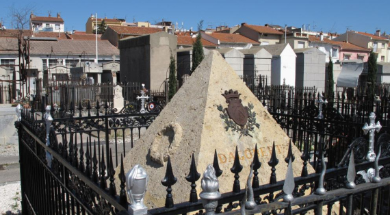 Tomeau en forme de pyramide entourée d'une grille, le blason de Dagobert:2 licornes et un lion séparé par un V pointe en haut.