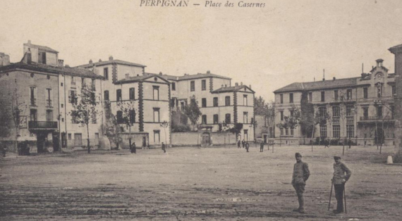 Photo ancienne : la place des casernes bordée par le collège avec 2 militaires au premier plan